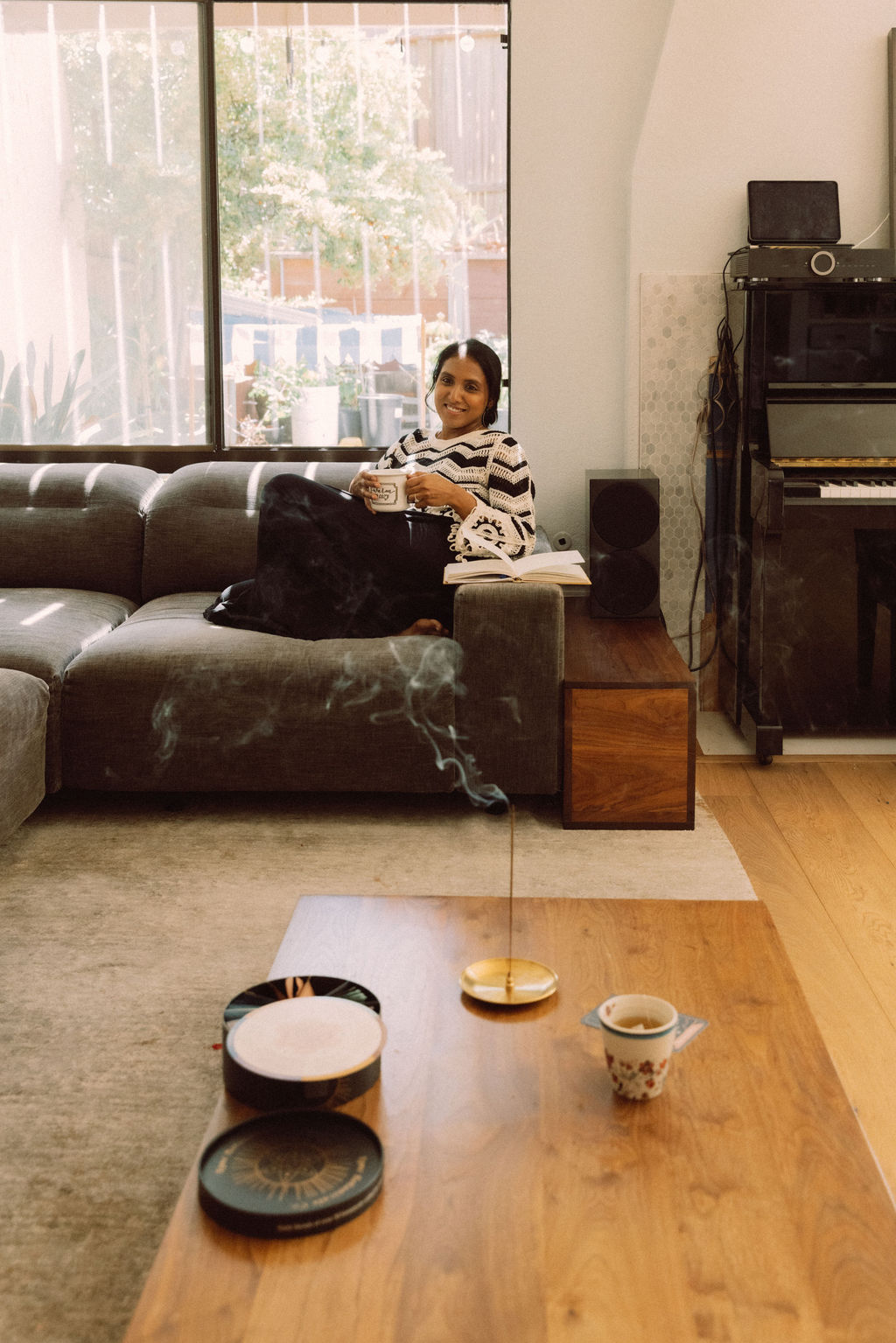 Divya relaxing at home with tea and a book